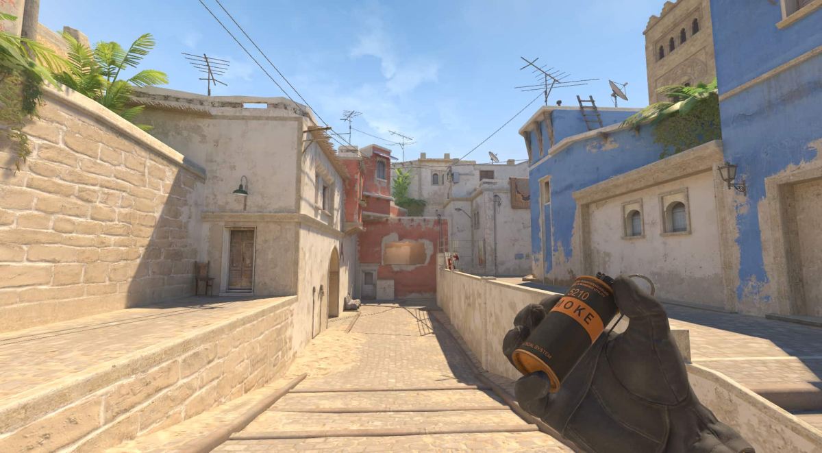 A CS2 player holding up a smoke nade on Mirage mid